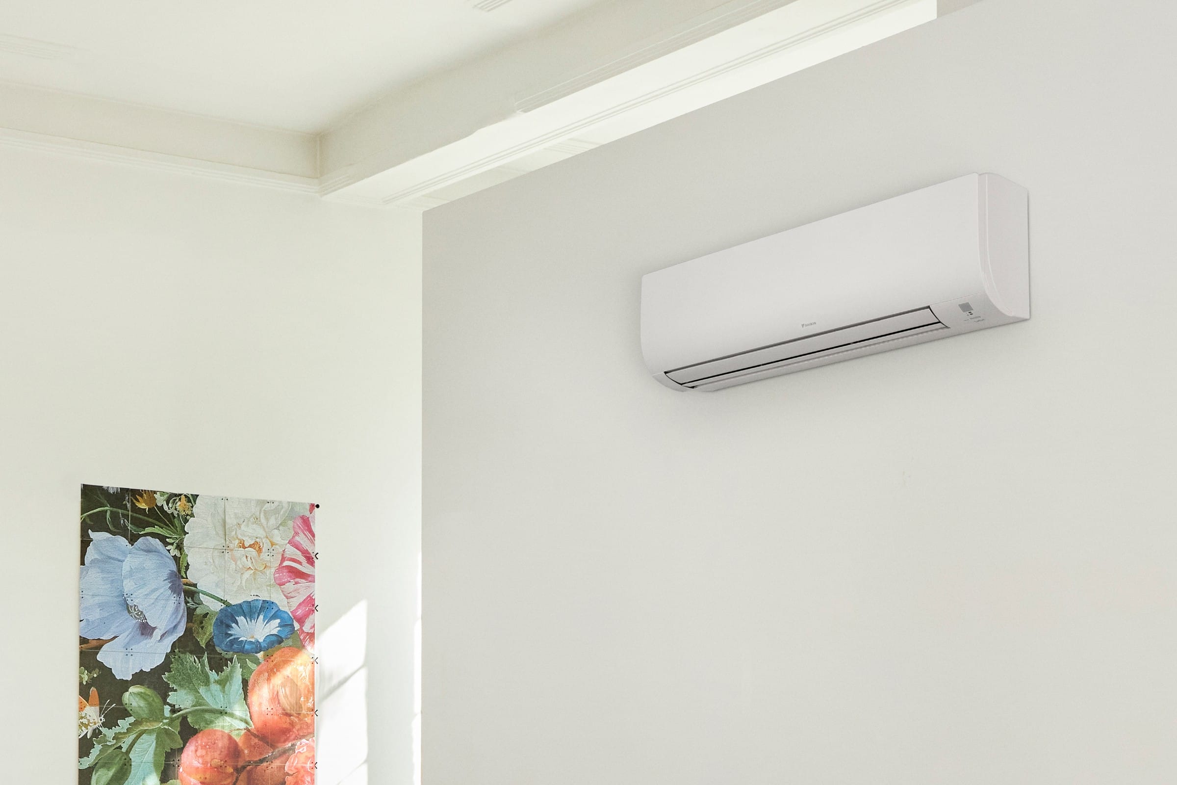 Baltas „Daikin Comfora“ FTXP25N vidinis blokas ant sienos jaukiame kambaryje