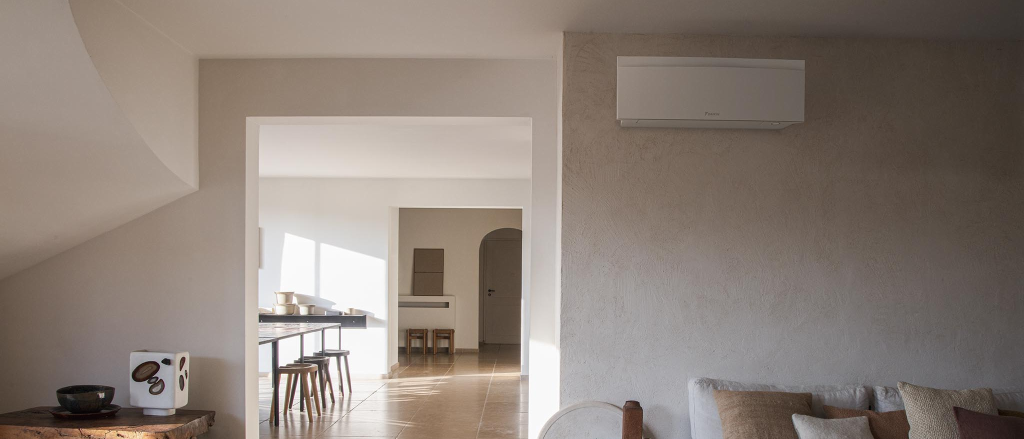 Matinis baltas „Daikin Emura“ FTXJ50AW vidinis blokas ant sienos šviesioje svetainėje