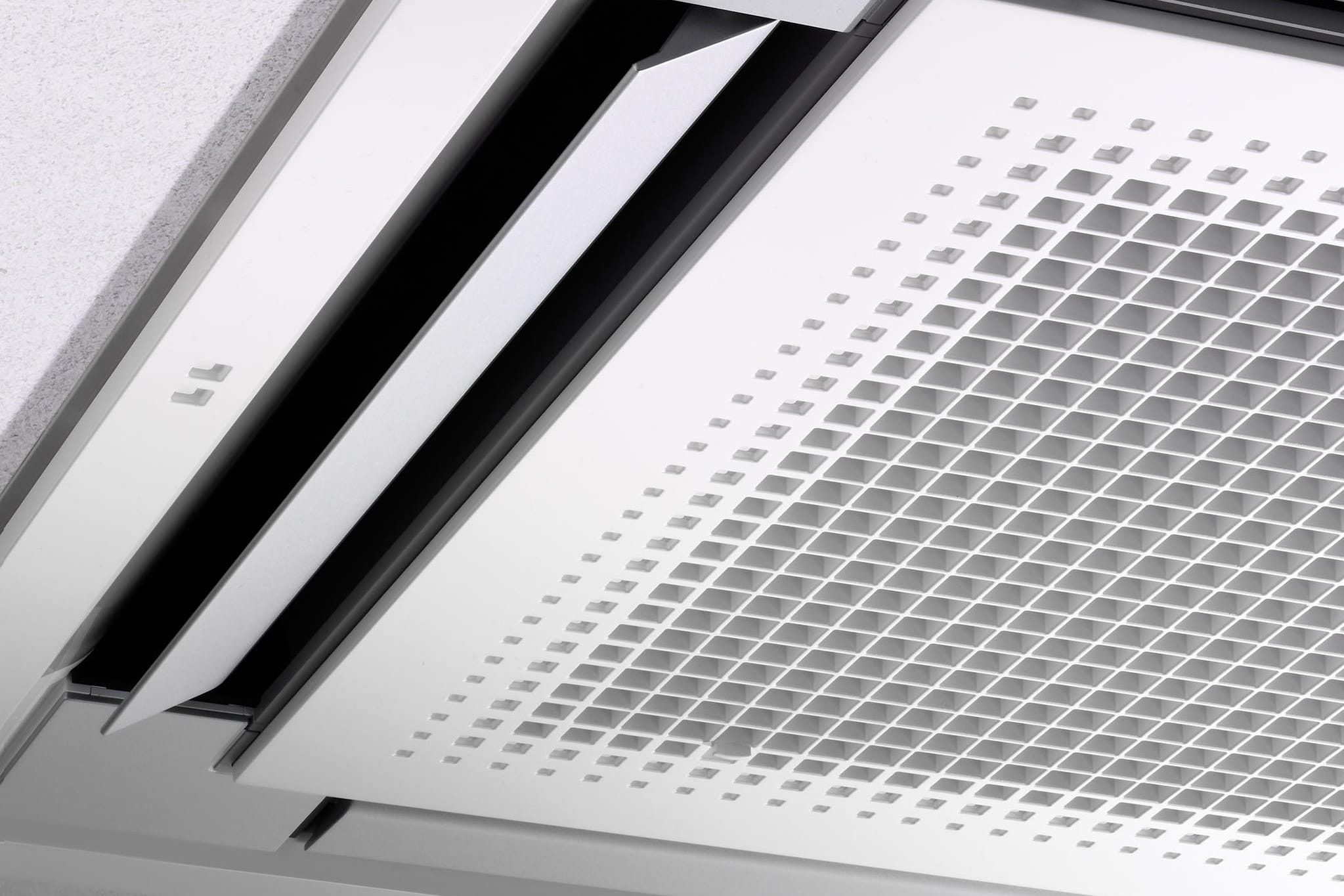 Daikin Fully Flat Compact FFA25A9: atverta plokščios „Daikin“ kasetės oro išpūtimo sklendė ir grotelės iš arti