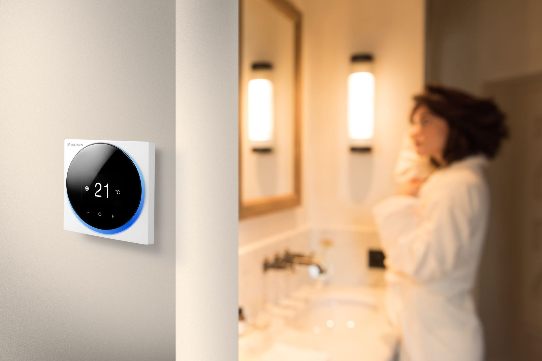 Baltas „Daikin Madoka“ laidinis pultelis ant sienos rodo 21 °C – pultelis parenkamas atskirai