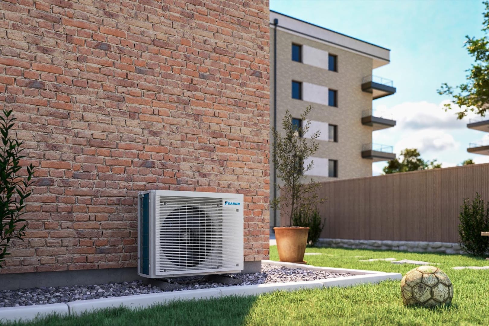 „Daikin“ multi-split lauko blokas ant žvyro juostos prie plytų namo sienos kieme
