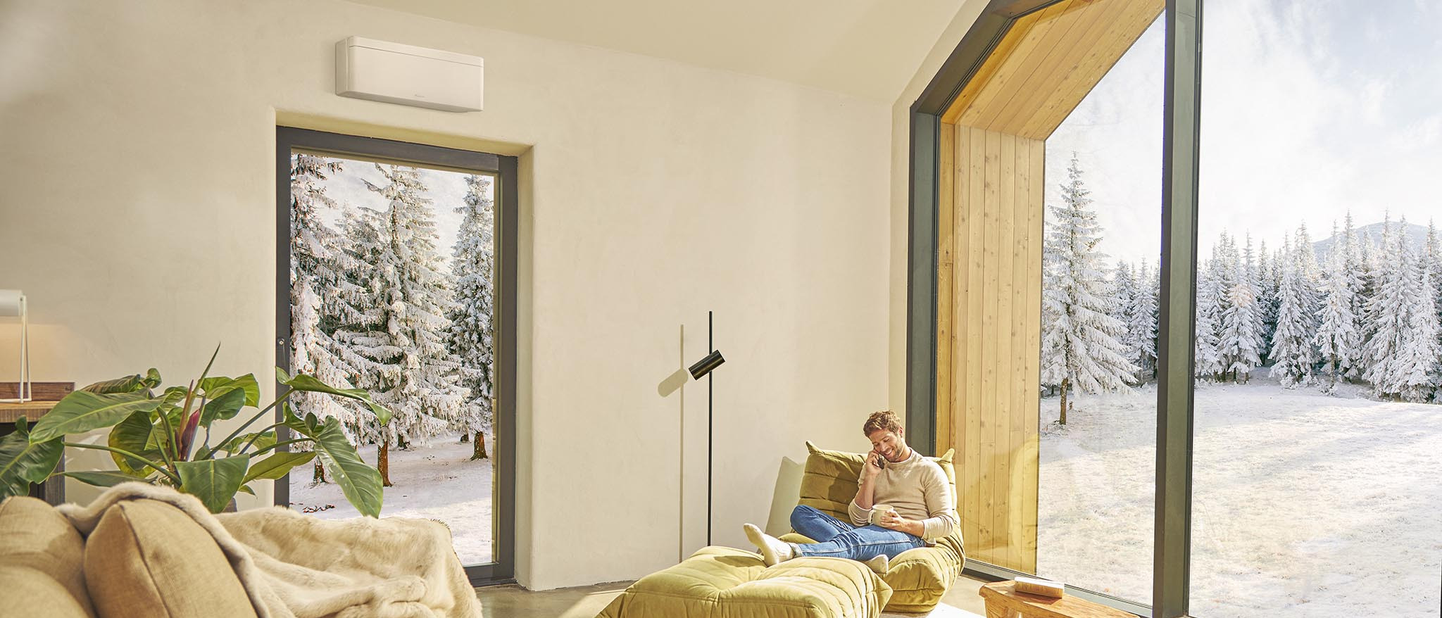 Baltas Daikin NORDIC Stylish FTXTA30CW šiaurietiško namelio svetainėje, už lango žiema