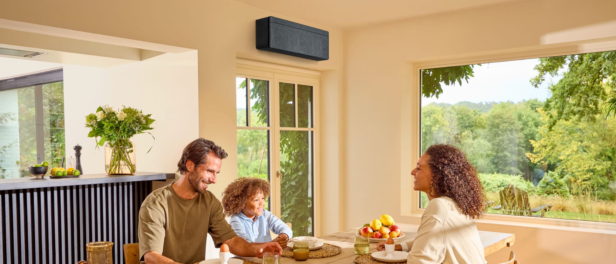 Daikin Stylish FTXA20DG su pilko audinio stiliaus skydeliu ir juodu korpusu šviesiame šeimos valgomajame