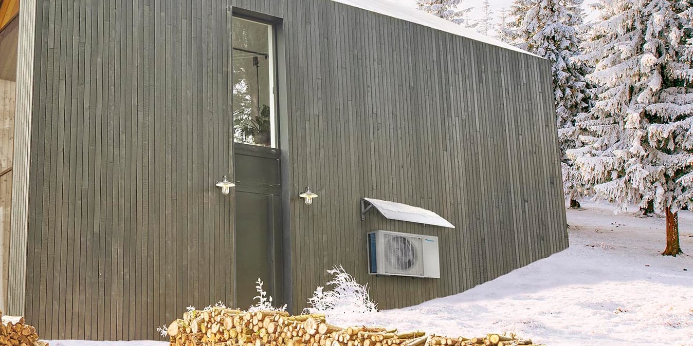 Daikin RXTM lauko blokas po stogeliu prie apsnigto namelio