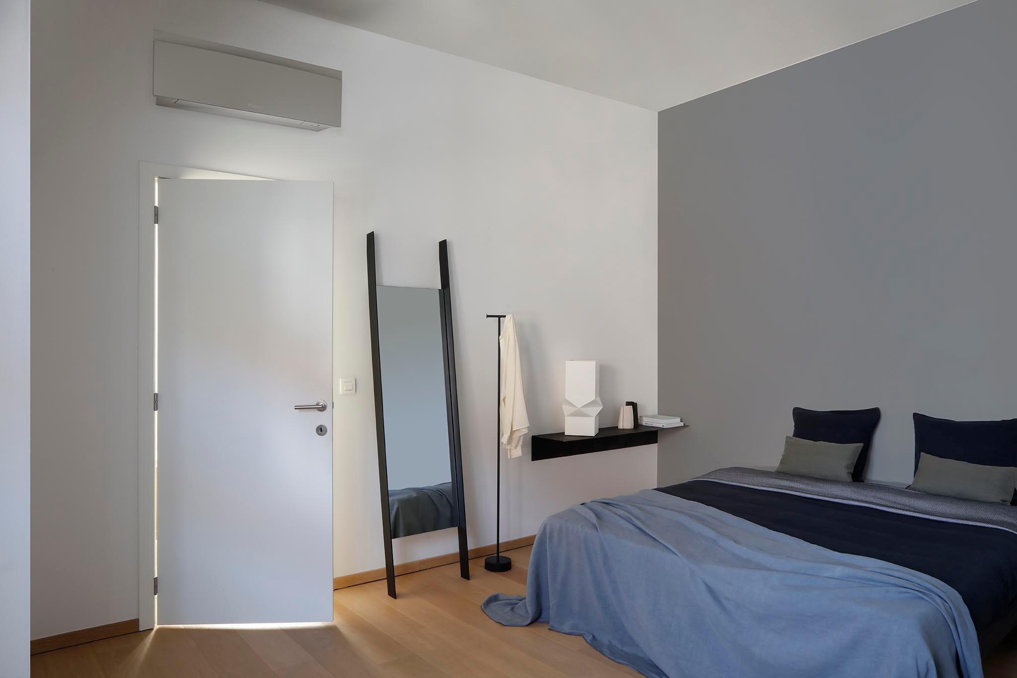 Sidabrinis Daikin Emura FTXJ50AS miegamajame