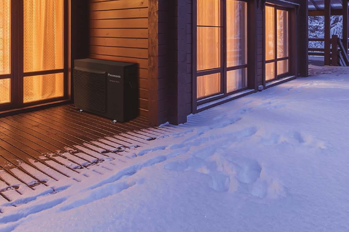 Panasonic Power Heat Multi CU-3Z75ABEC tamsus lauko blokas ant medinės terasos prie namo žiemos vakarą